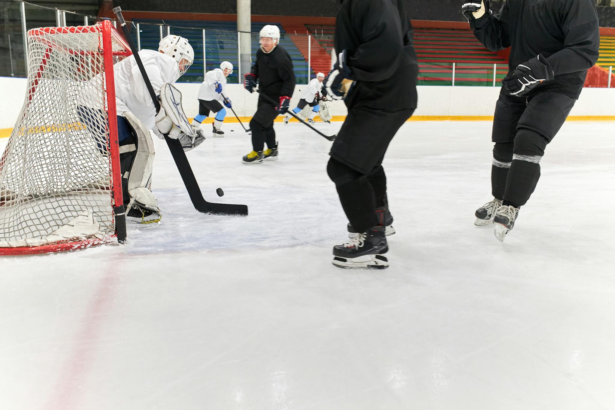 Intense ice hockey match with players in action on the ice rink, showcasing a goalie block.